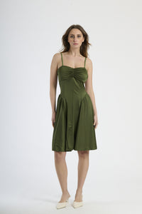 Donna con abito di colore militare a spalline, carattere ed edginess.