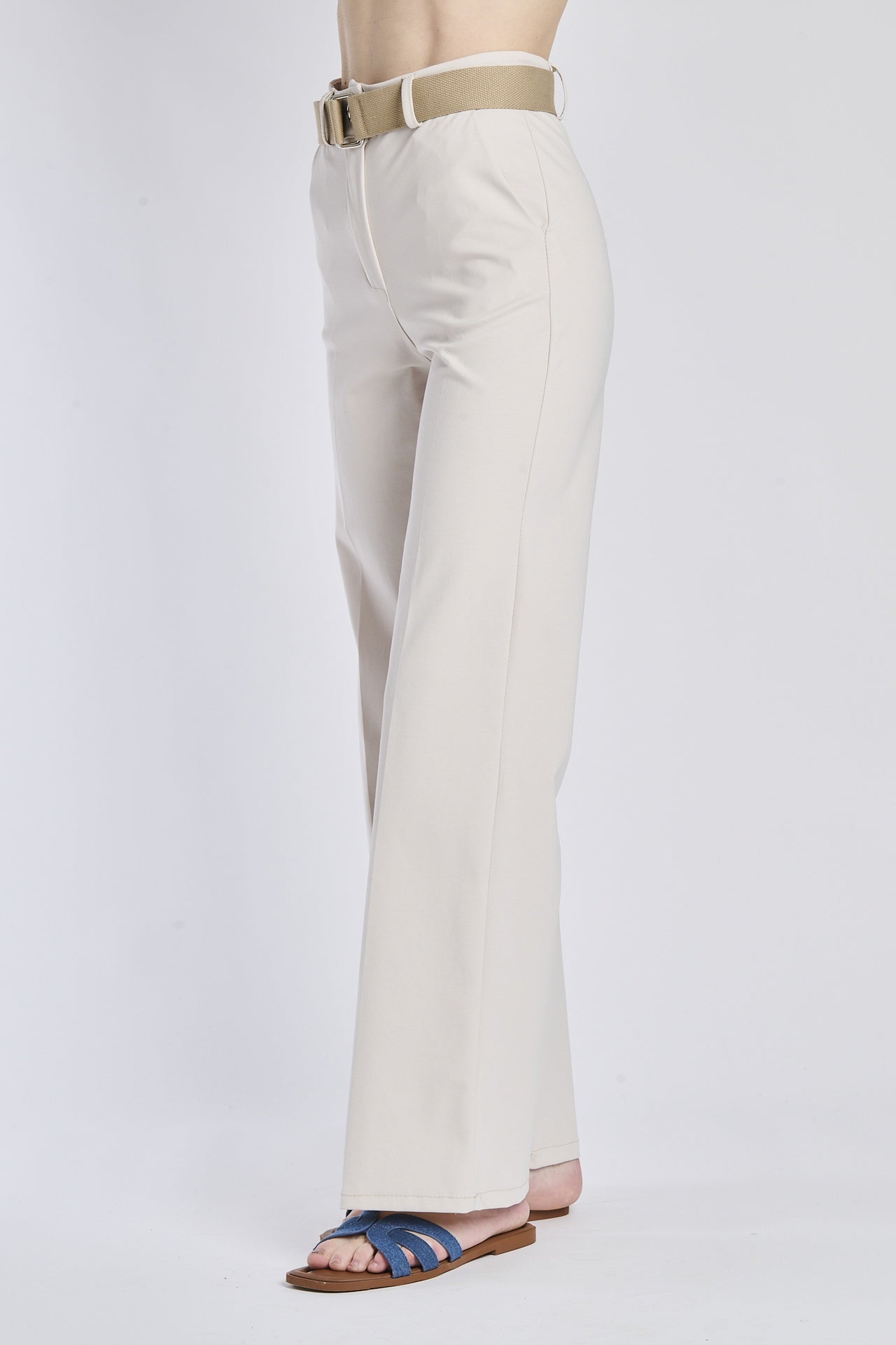 Pantaloni bianchi, cintura beige e sandali piatti blu