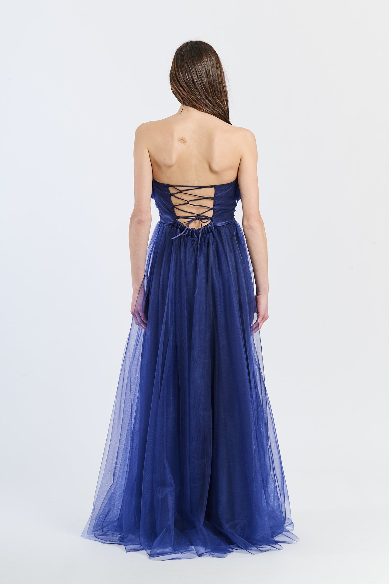 Abito romantico navy in tulle satinato, scollo a barca e drappeggi raffinati, perfetto per shoot notturni e serate eleganti