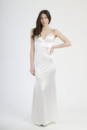 Donna con abito bianco in raso, purezza ed eleganza luminosa.