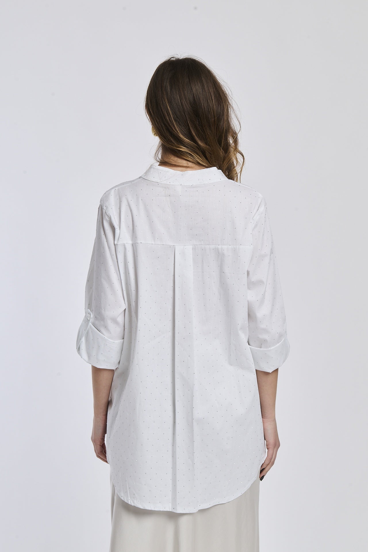 Camicia bianca oversize, colletto alto, maniche arrotolate, stile pulito e versatilità.