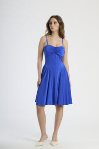 Donna con abito bluette a spalline, serenità e eleganza rinfrescante.