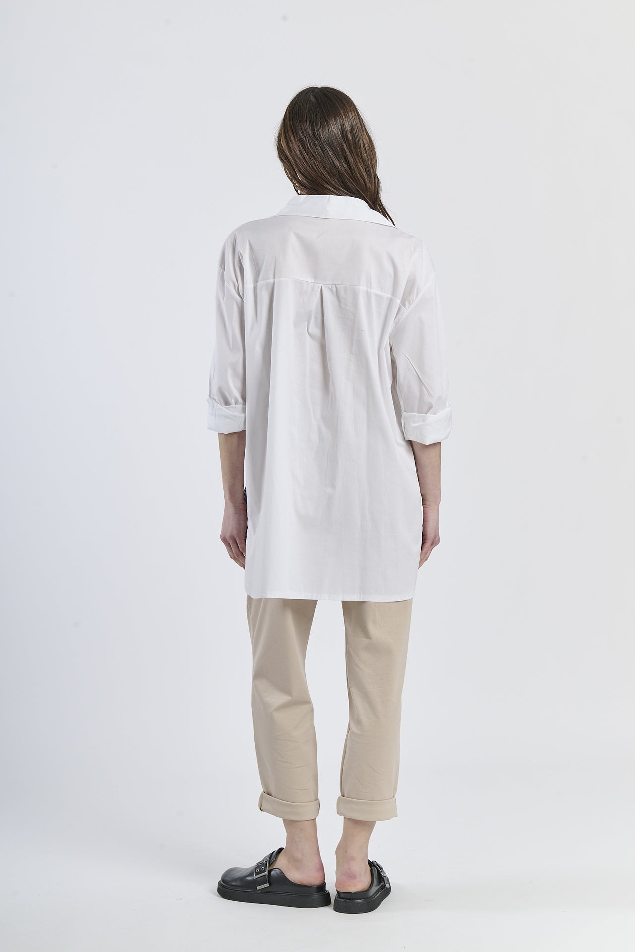 Outfit casual con camicia a righe navy asimmetrica, dettaglio floreale e pantaloni marroni, scarpe mocassini rame