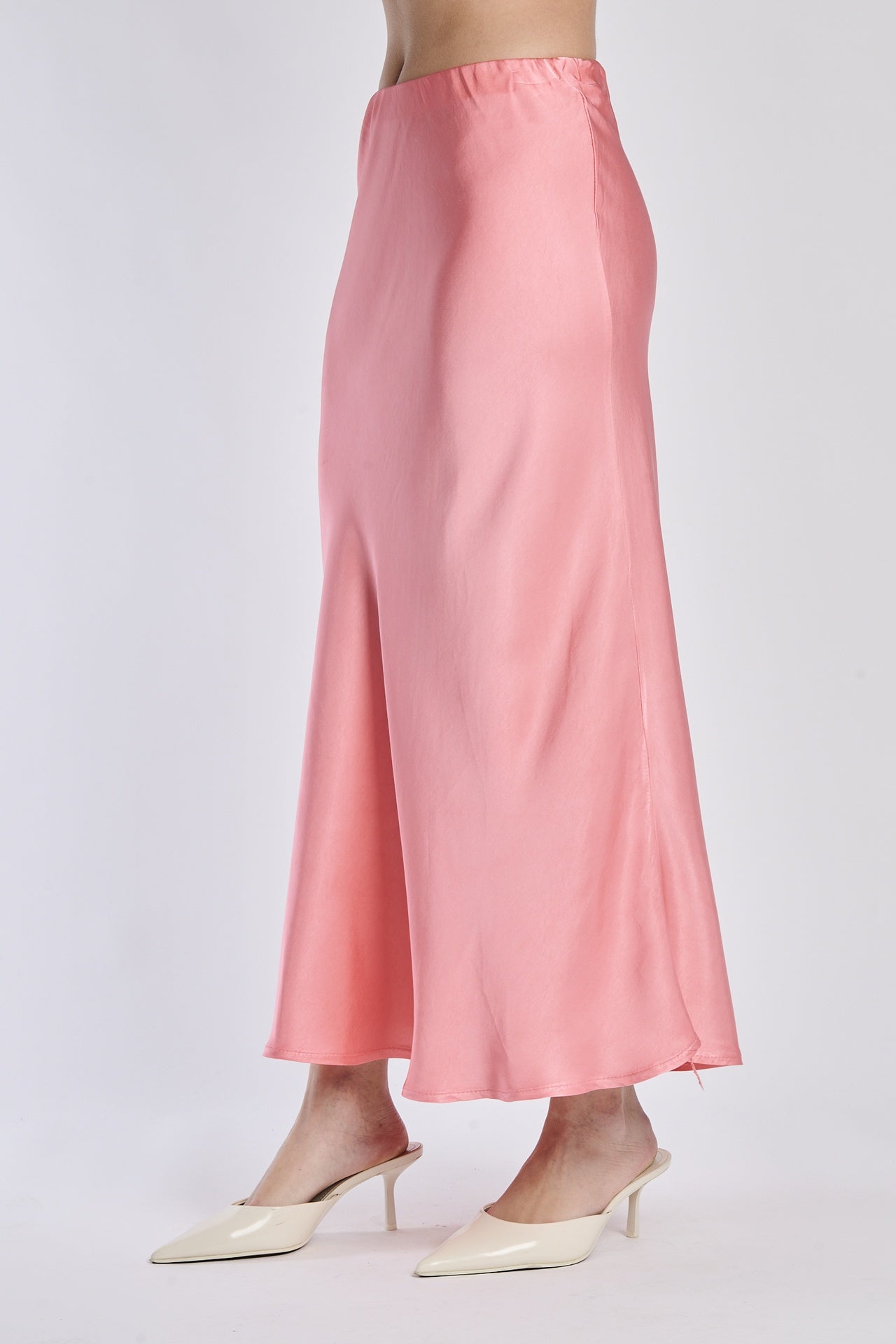 Gonna corallo in raso lucido, vista frontale con scarpe alti tacchi