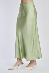 Gonna verde in raso lucido, vista frontale con scarpe alti tacchi