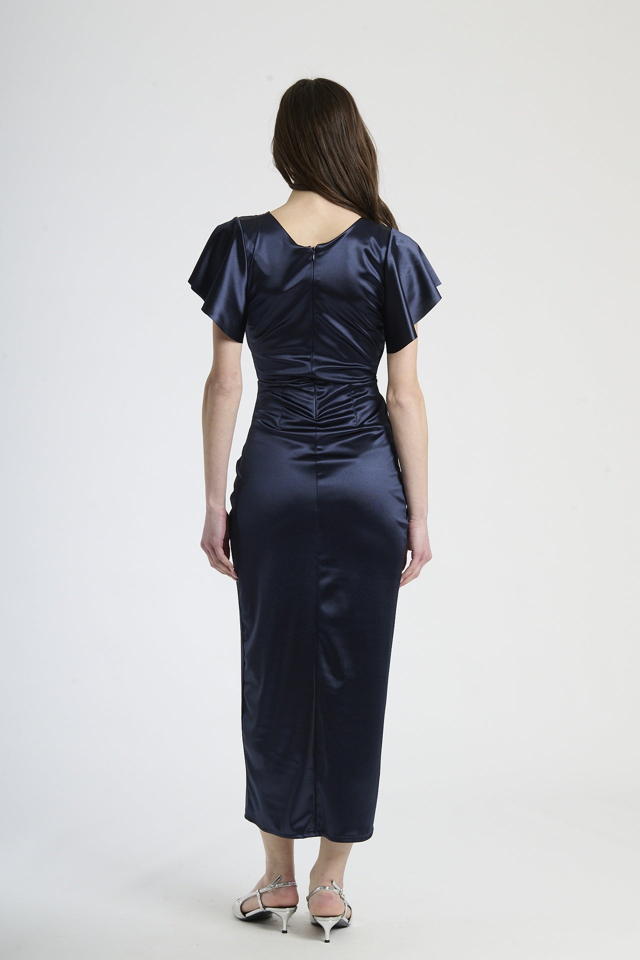 Modella in abito navy a scollatura V, stile preppy per serate formali.