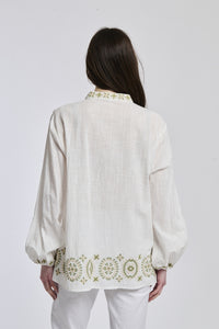 La giacca marrone di lana con maniche a muffa e bottoni decorativi, abbinata a pantaloni scuri, è perfetta per un'uscita in città in un pomeriggio autunnale.