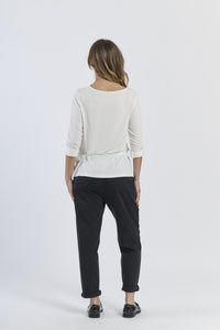 Blusa bianca a maniche 3/4, abbinata a pantaloni neri, minimalismo raffinato