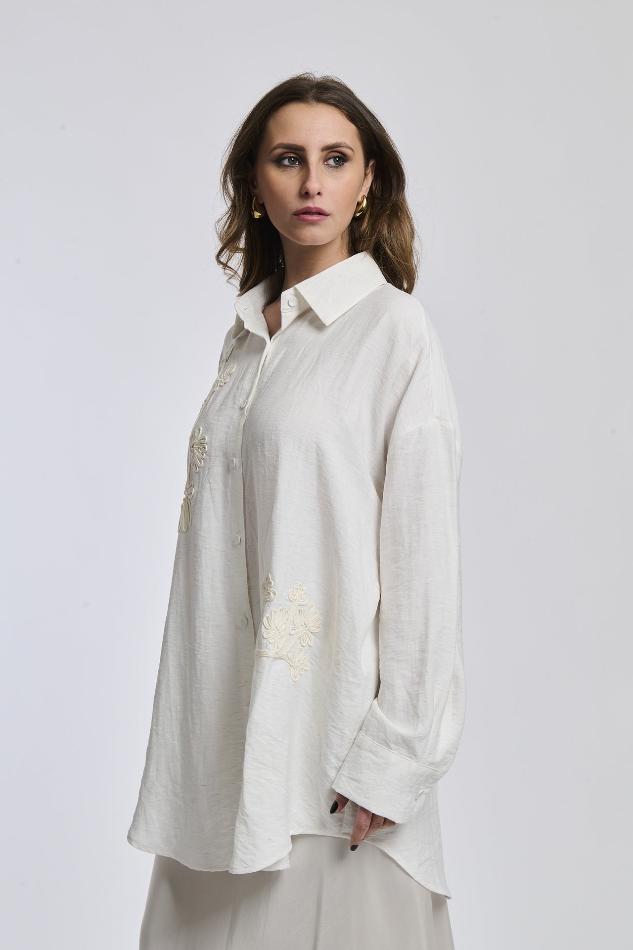 Camicia bianco indossata dalla donna, con un disegno semplice e linee pulite