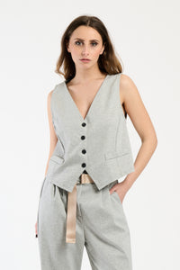 Outfit grigio: gilet corto e pantaloni ampi, perfetto per un look elegante e discreto.