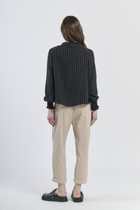 Top nero concollo asimmetrico e stile minimalista