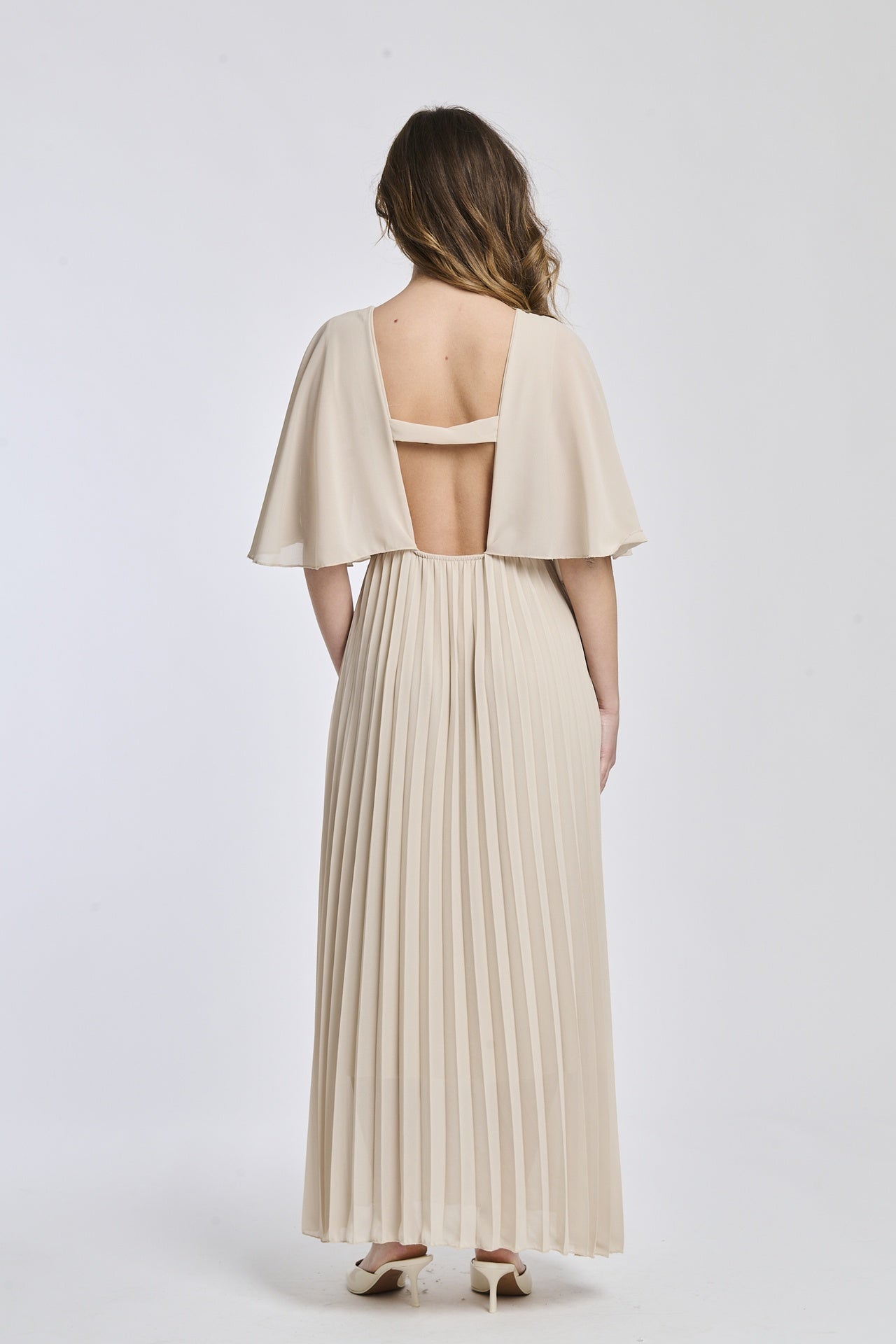 Vestito beige con falde al fondo, mantenendo lo stile semplice e classico, ideale per un look quotidiano e distinto.