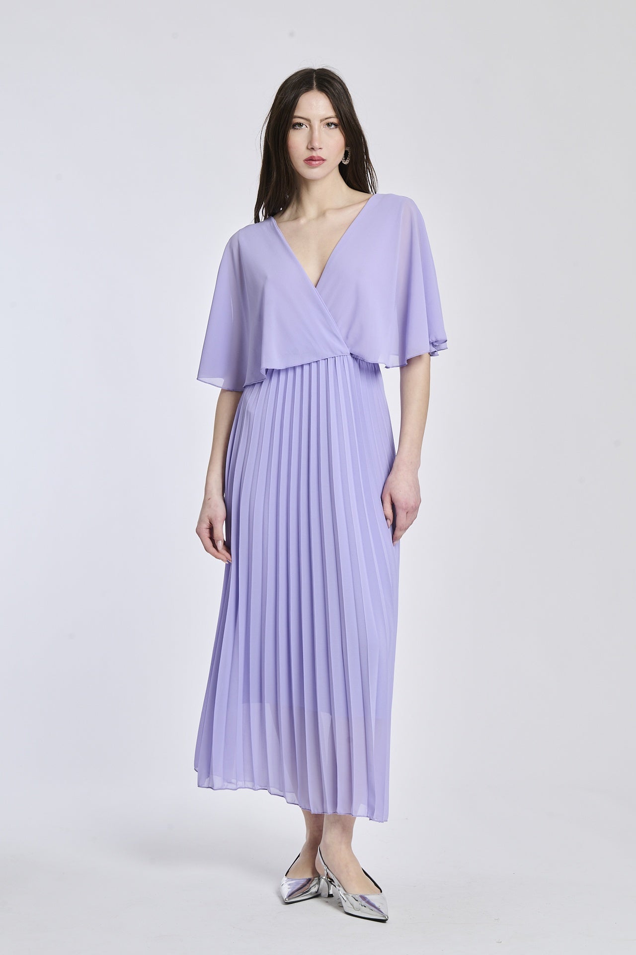 Un abito in lilla con lo stesso disegno crociato e maniche a mantello, creando un'atmosfera di magia e fantasia.