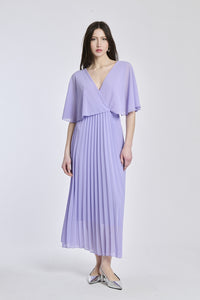 Un abito in lilla con lo stesso disegno crociato e maniche a mantello, creando un'atmosfera di magia e fantasia.