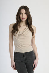 Donna con canotta beige, eleganza neutra e sofisticata.