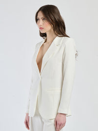 Ensemble bianco: blazer con linee pulite e pantaloni, simbolo di eleganza minimalista.