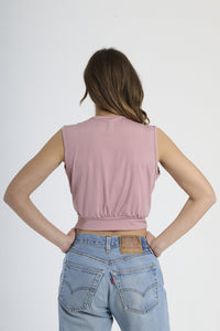 Top corto rosa antico senza maniche, scollatura a V profonda e fibbia decorativa sul busto.