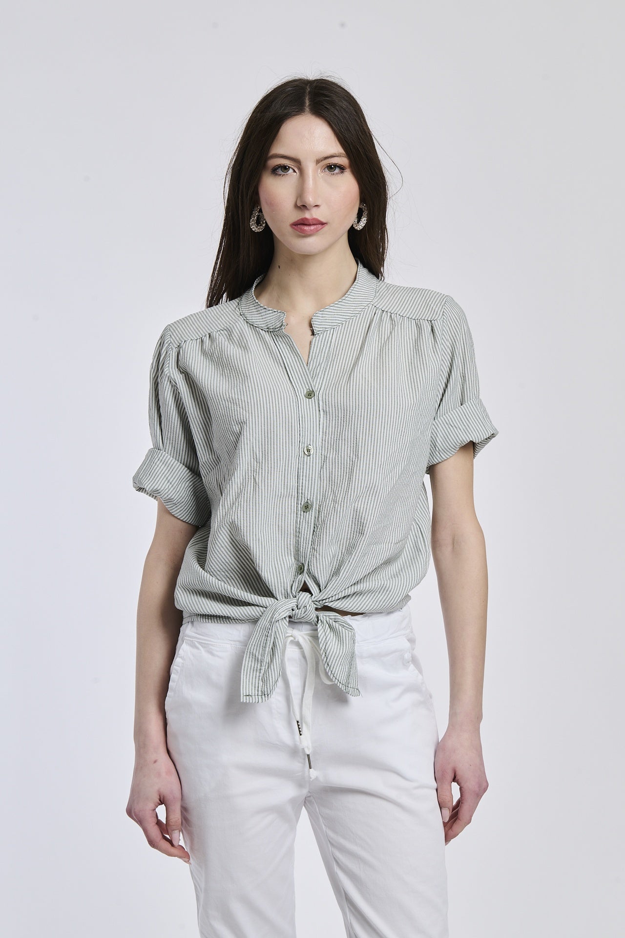 Camicia a righe militares e bianche da donna, nodo sul ventre, che dona un’aria casual e energica.