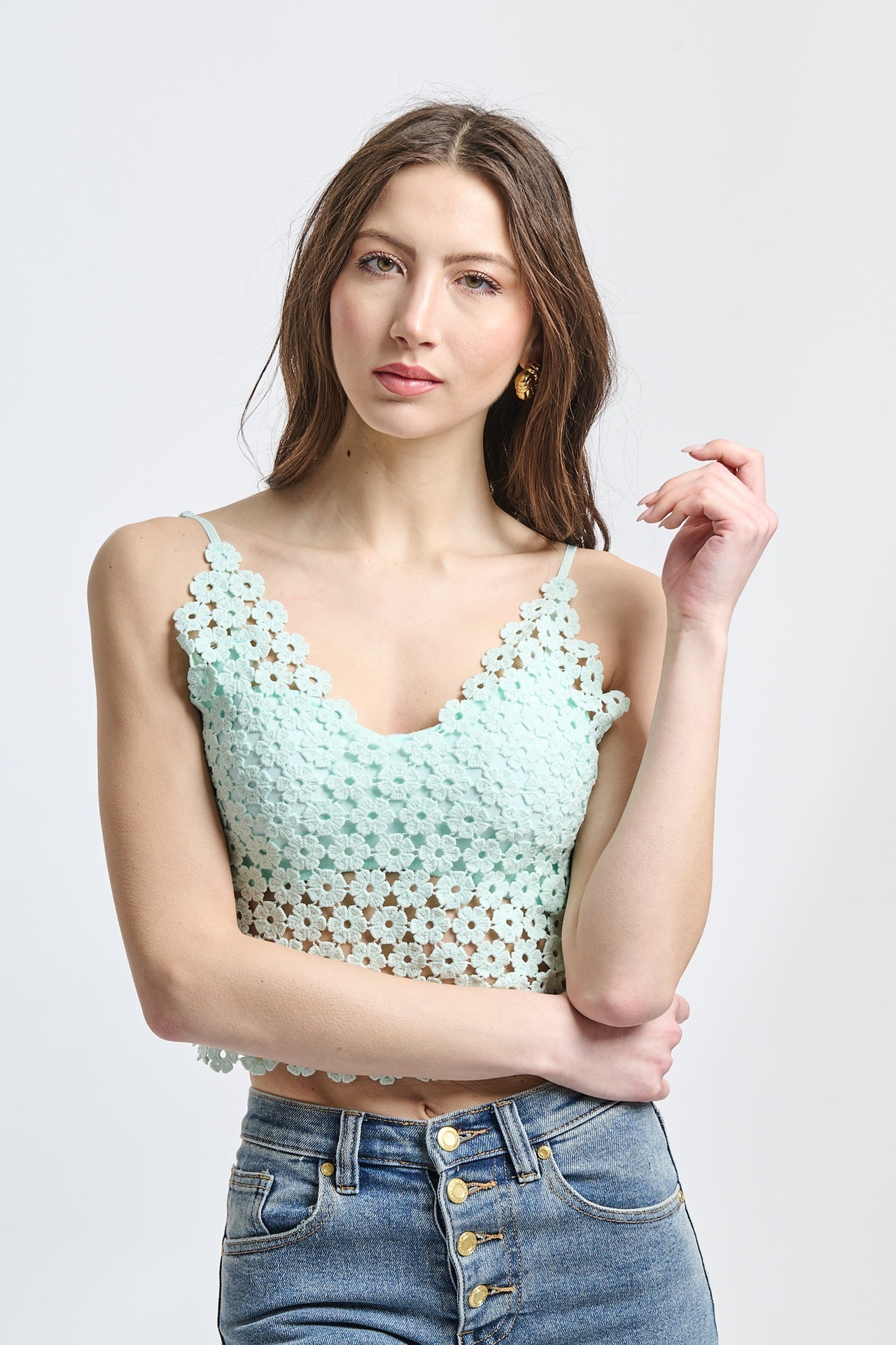 Top cropped verde menta a uncinetto, con scollatura a V e bretelle sottili, stile rinfrescante.