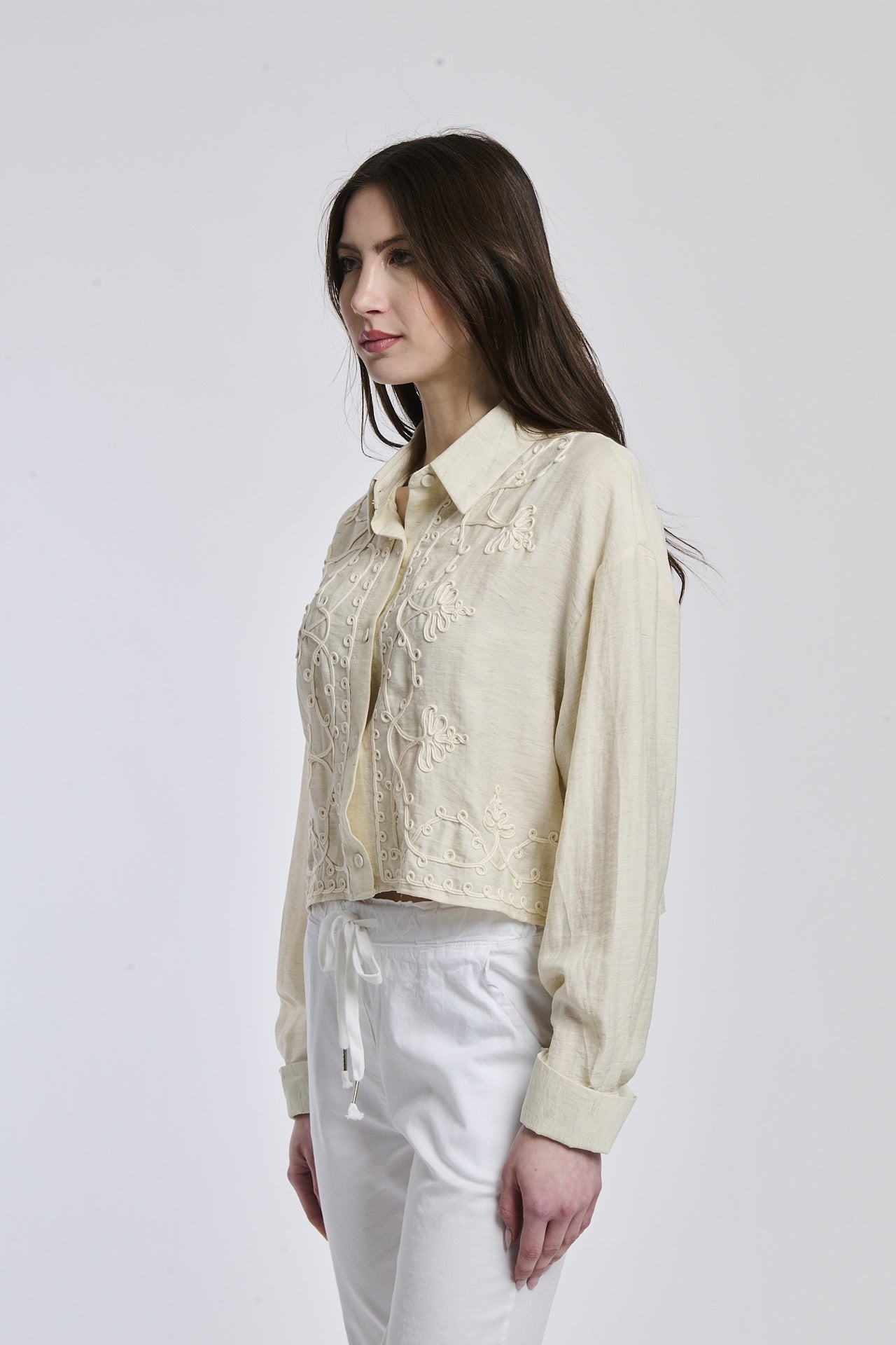 Camicia a righe blu scuro e bianco indossata dalla donna, con un leggero slittamento e un nodo alla vita, che trasmette un’atmosfera di leggerezza e eleganza.