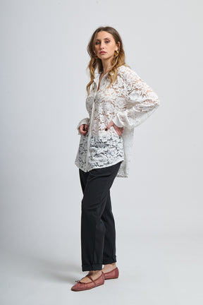 Camicia bianca a fantasia, collo classico e maniche lunghe, abbinata a scarpe mocassini.