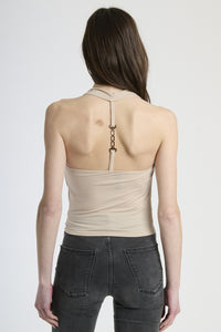 Modella in canotta beige, stile classico e versatile.