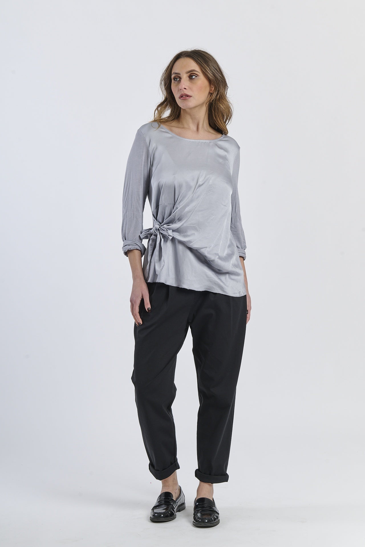 Blusa grigia oversize con nodo, sobrietà e modernità