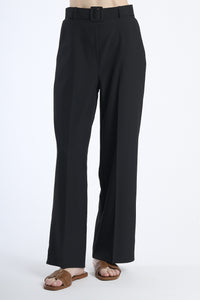 Pantaloni larghi neri con cintura, taglio a zampa, abbinati a sandali.