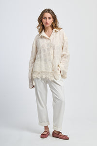 Outfit con maglia rosa scura a colletto alto e pantaloni grigi chiari, stile moderno e elegante.