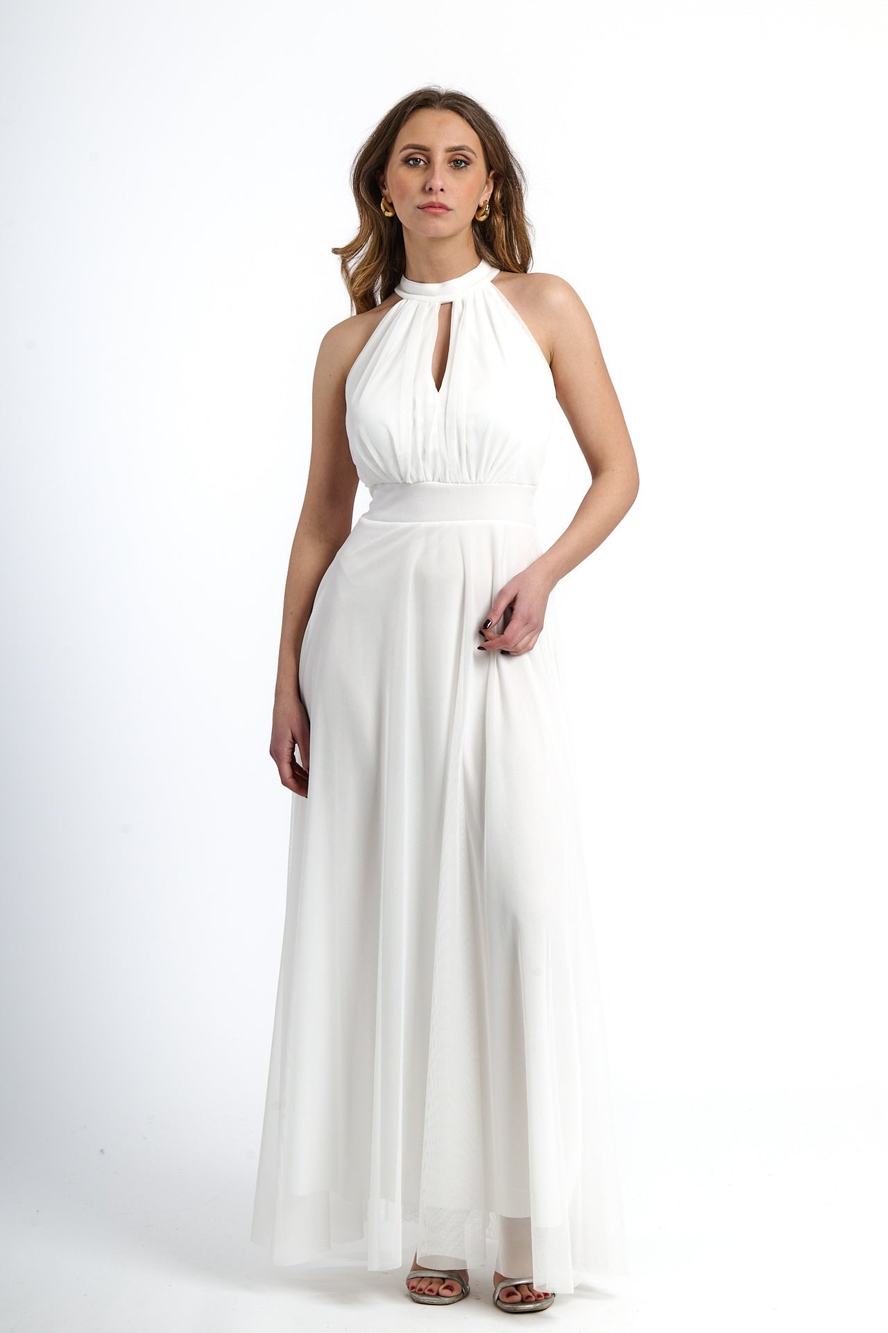 Donna con abito lungo bianco, design colletto, pianta verde tropicale accanto