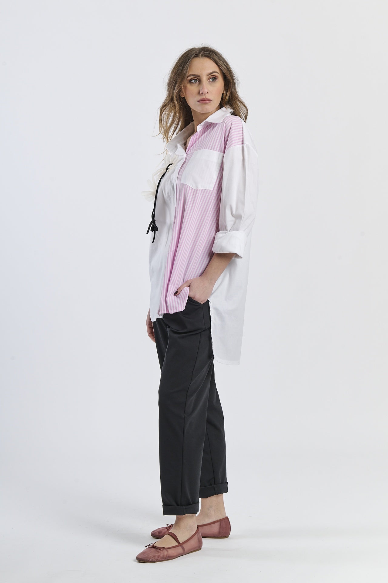 Look fashion con camicia bicolor a righe, colletto classico, maniche a 3/4 e decorazione floreale, abbinata a pantaloni scuri