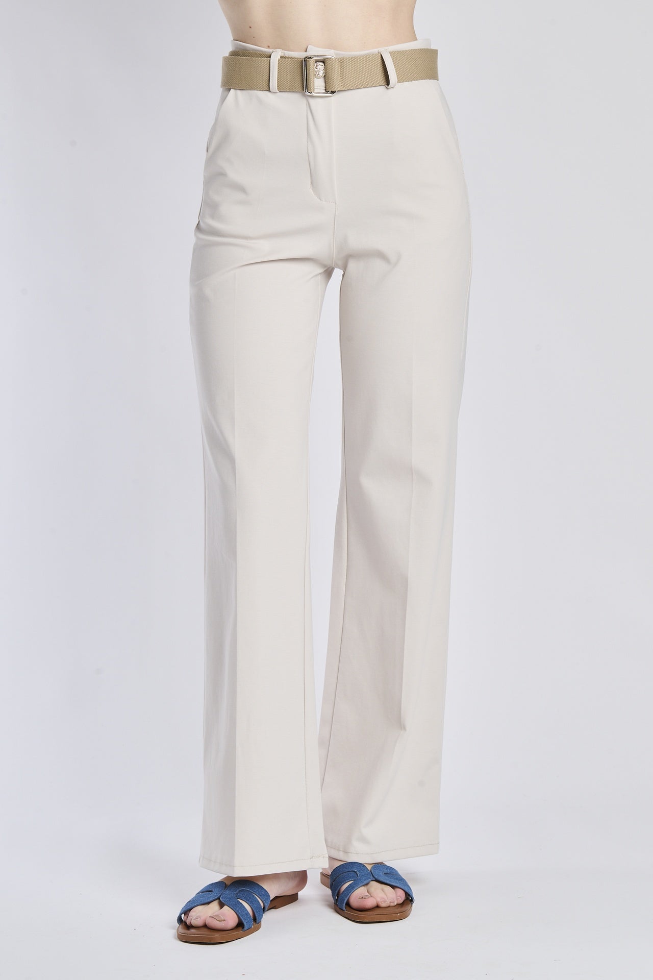 Pantaloni bianchi con cintura beige e sandali blu