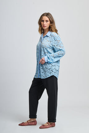 Camicia azzurra a fantasia, collo classico e maniche lunghe, abbinata a scarpe mocassini.