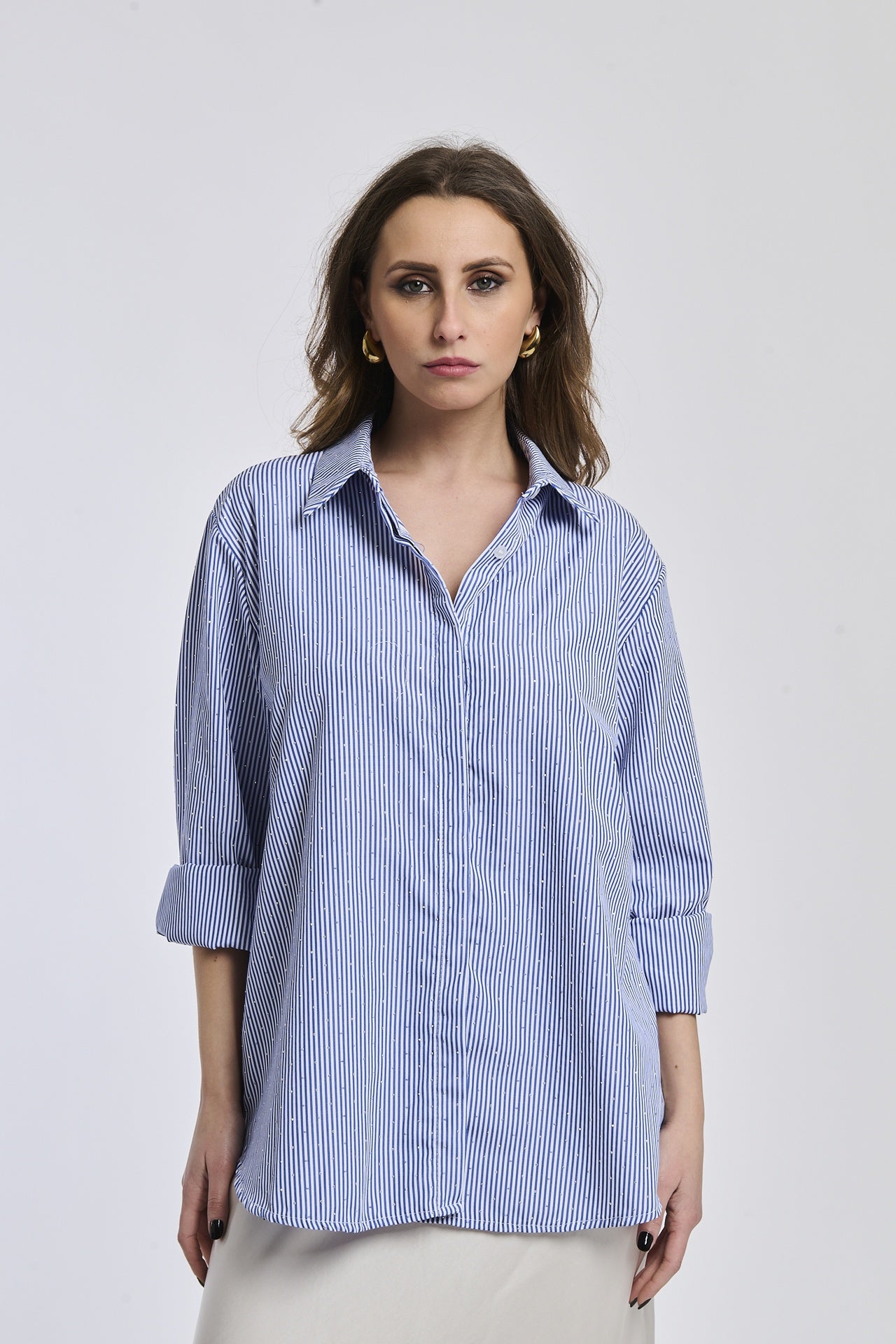 Donna con camicia a righe blu e bianche, colletto a camicia, maniche arrotolate a 3/4