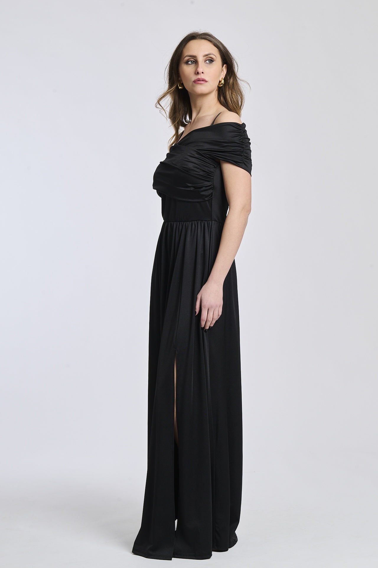 Abito nero lungo, design a spalline scollate, fascia in vita e apertura laterale, ideale per serate speciali.