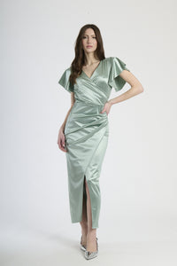 Donna con abito salvia in velluto, tranquillità naturale ed eleganza rinfrescante.