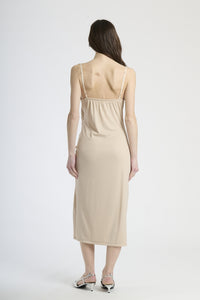 Vestito beige in tessuto morbido, design con ruches e spalanca, adatto per occasioni sofisticate.