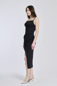 Abito nero aderente, spalline sottili e apertura laterale, perfetto per un outfit da sera o speciale.