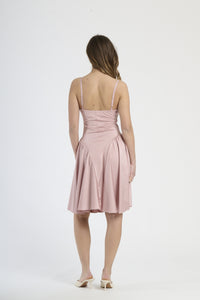 Modella indossa abito rosa antico, stile delicato e nostalgico.