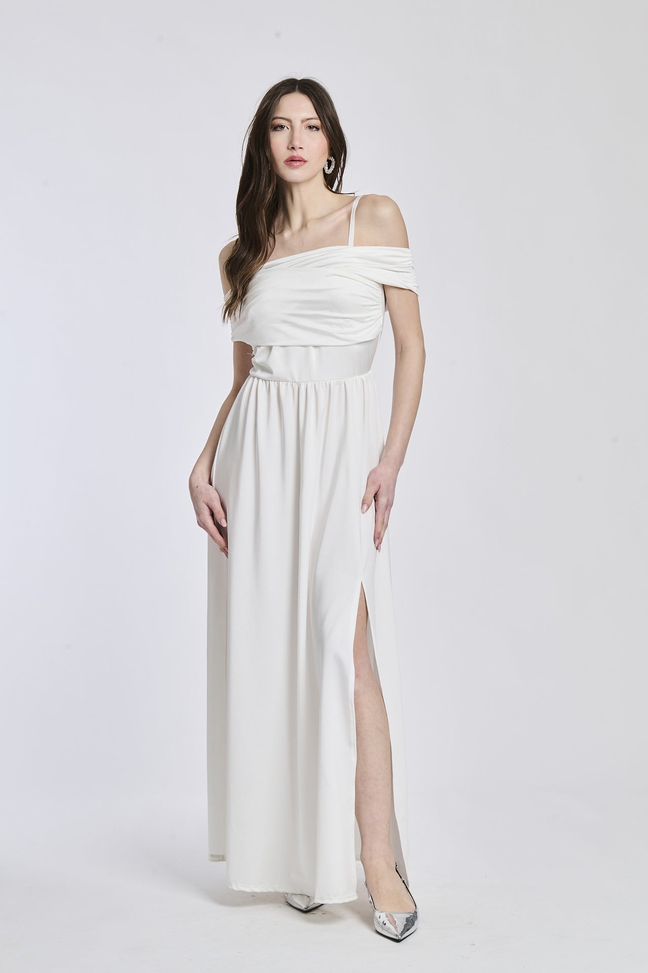 Abito bianco a spalline scollate, taglio fluido, fascia in vita che dona un’aria pulita.