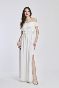 Abito bianco a spalline scollate, taglio fluido, fascia in vita che dona un’aria pulita.