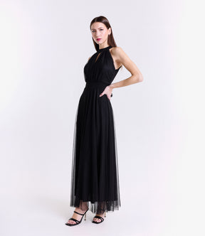Abito nero elegante, design halter, gonna fluida, pianta verde decorativa