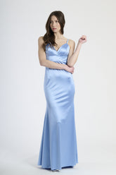 Donna con abito azzurro in raso, eleganza rinfrescante e luminosa.