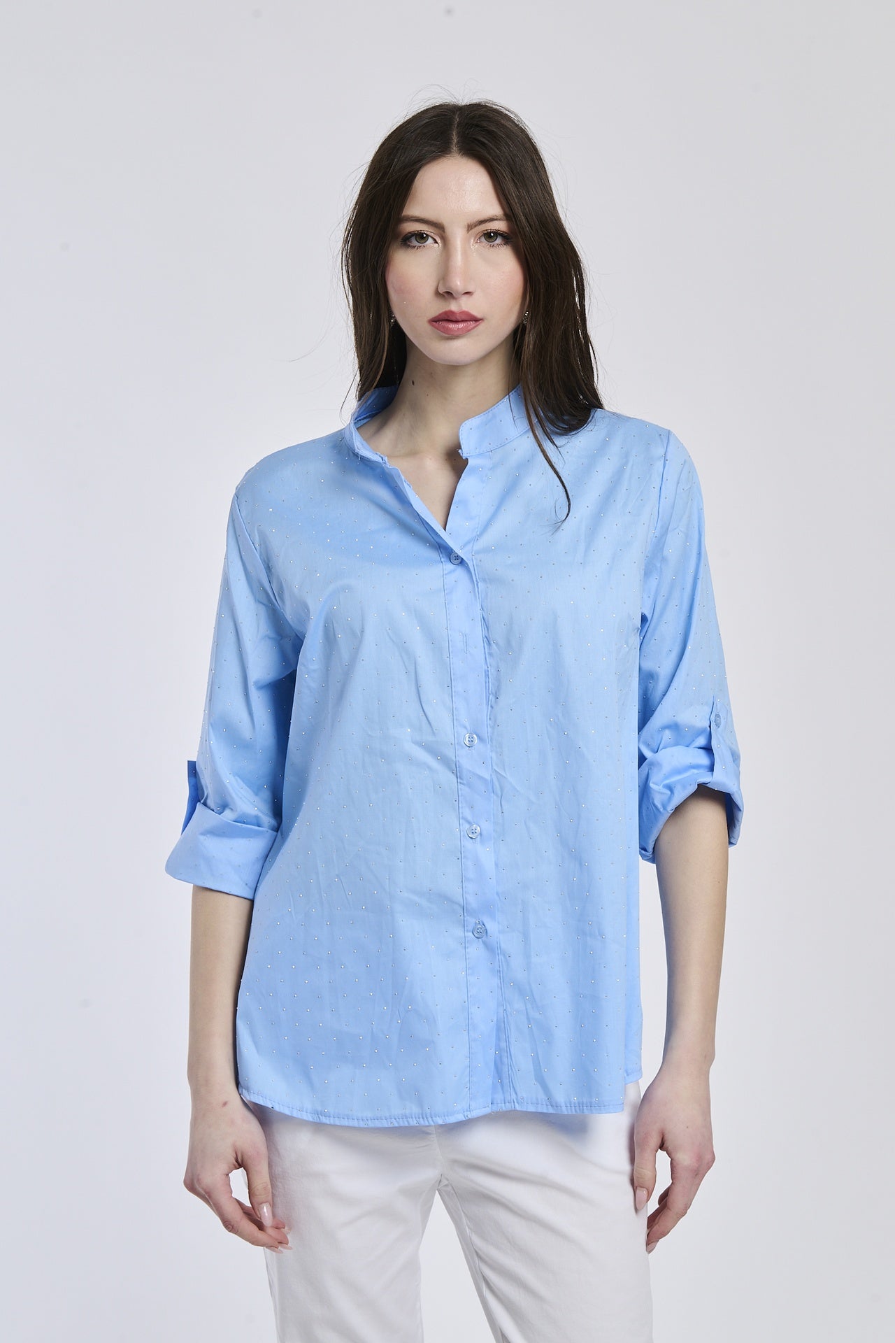 Camicia oversize azzurra, colletto alto, bottoni frontali e maniche arrotolate, perfetta per l’uso quotidiano.