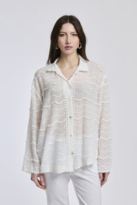  Donna in abbigliamento estivo: camicia bianco a uncinetto e pantaloni bianchi, posa stilosa