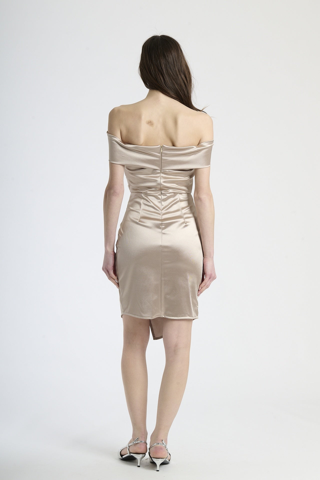 Modella in abito beige con plissé, stile classico e versatile per occasioni formali.