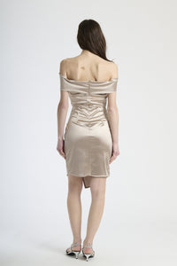 Modella in abito beige con plissé, stile classico e versatile per occasioni formali.