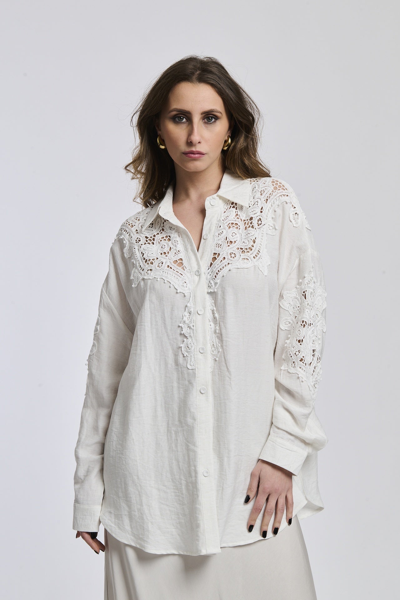 Una donna veste una camicia di un colore blu oscuro, la quale sottolinea la sua personalità profonda e riflessiva.