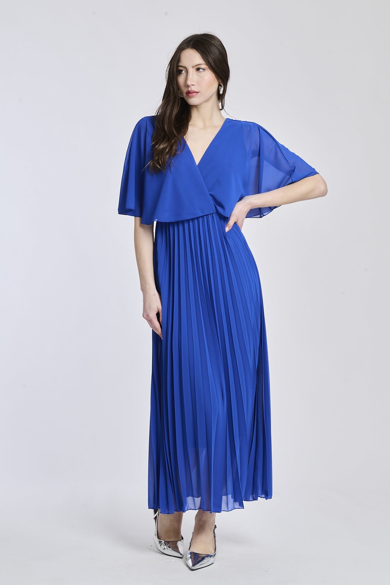 Un vestito in bluette chiaro, con il taglio crociato sul busto e le maniche a mantello del modello originale, che dà un senso di freschezza e tranquillità.