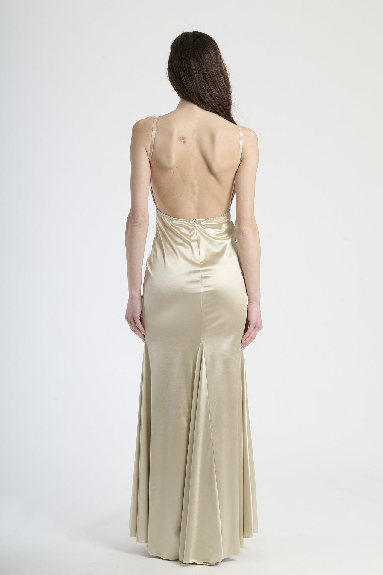 Modella in abito beige a spalline, stile classico e versatile per occasioni formali.